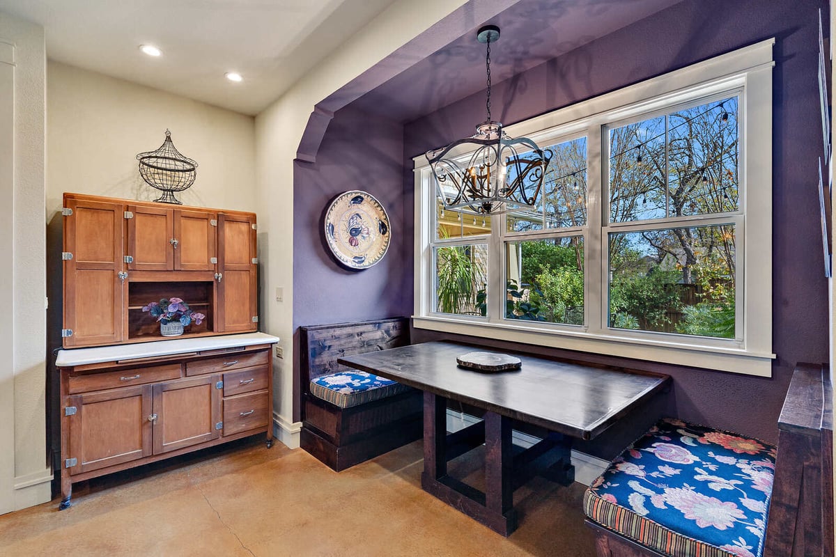 Cozy breakfast nook with a large window and rustic wooden furniture in a custom home by J Bryant Boyd, Georgetown, TX