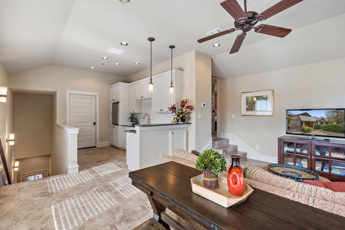 Cozy family room with an open kitchen and white cabinets in a Georgetown, TX custom home by J Bryant Boyd