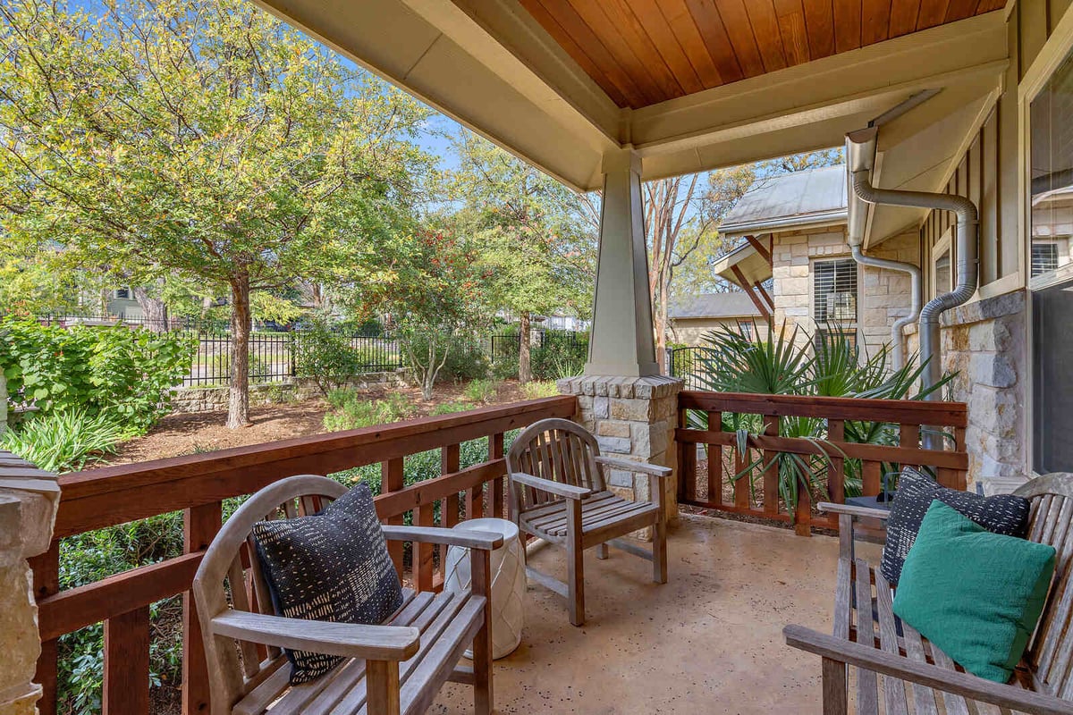 Cozy front porch with wooden chairs and garden views, custom home by J Bryant Boyd in Georgetown, TX