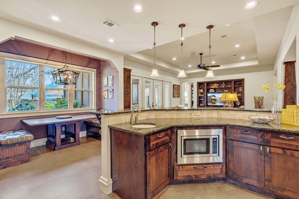 Cozy kitchen breakfast nook with a large window and wooden benches in a custom home by J Bryant Boyd, Georgetown, TX