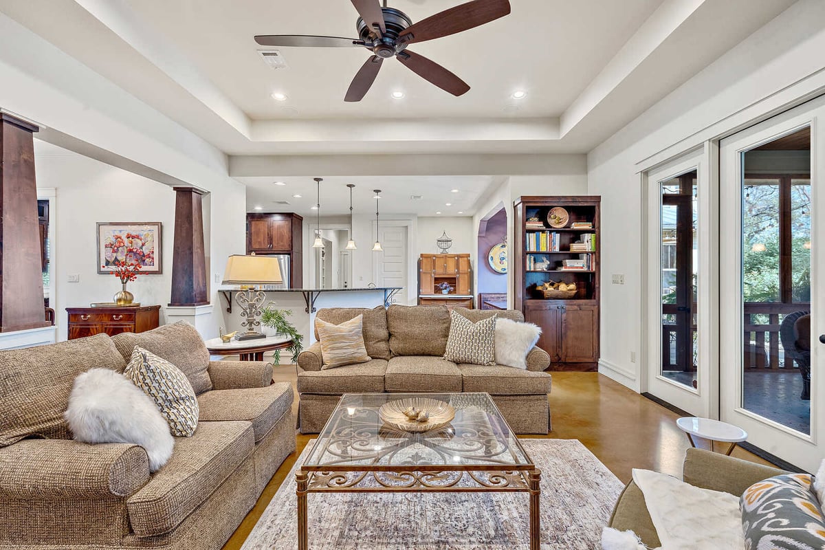 Cozy living room with built-in bookshelf and access to a screened porch in a custom home by J Bryant Boyd in Georgetown, TX