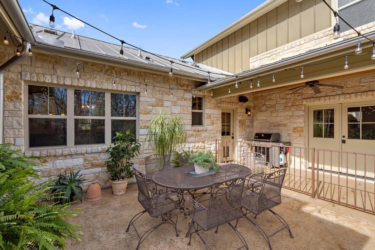 Cozy outdoor patio with string lights and lush plants, custom home by J Bryant Boyd in Georgetown, TX