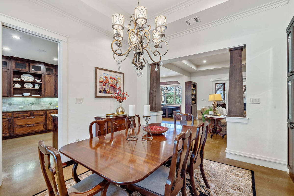 Custom home dining room with large windows and chandelier by J Bryant Boyd in Georgetown, TX