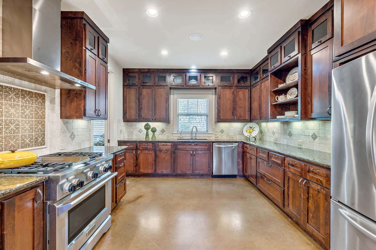 Custom home kitchen with stainless steel range and wooden cabinets by J Bryant Boyd, Georgetown, TX