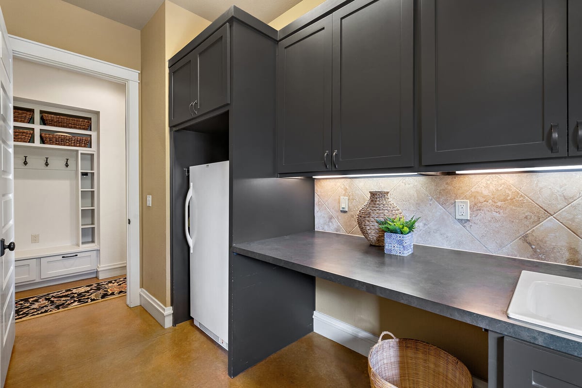 Custom laundry room with dark cabinetry and built-in storage in a Georgetown, TX home by J Bryant Boyd