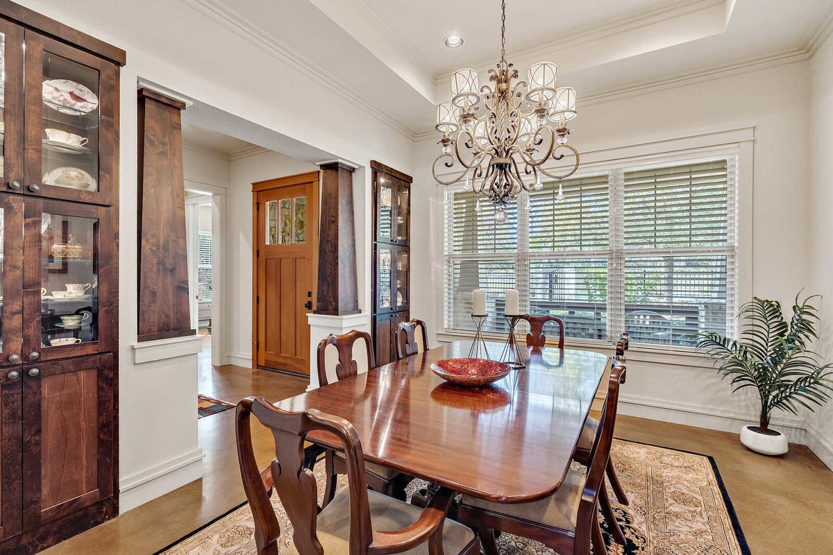 Elegant dining room with decorative chandelier and large windows in a custom home by J Bryant Boyd in Georgetown, TX