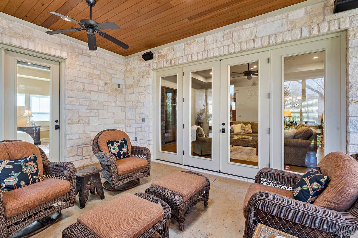 Enclosed patio with ceiling fans and stone walls, custom home by J Bryant Boyd in Georgetown, TX