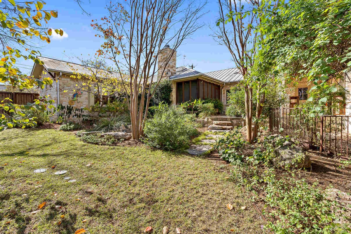 Expansive garden and backyard view of a custom stone home by J Bryant Boyd in Georgetown, TX