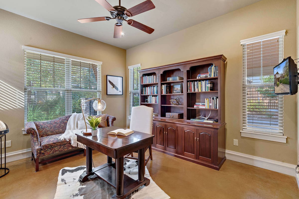 Home office with built-in bookshelves and natural light in a custom home by J Bryant Boyd, Georgetown, TX