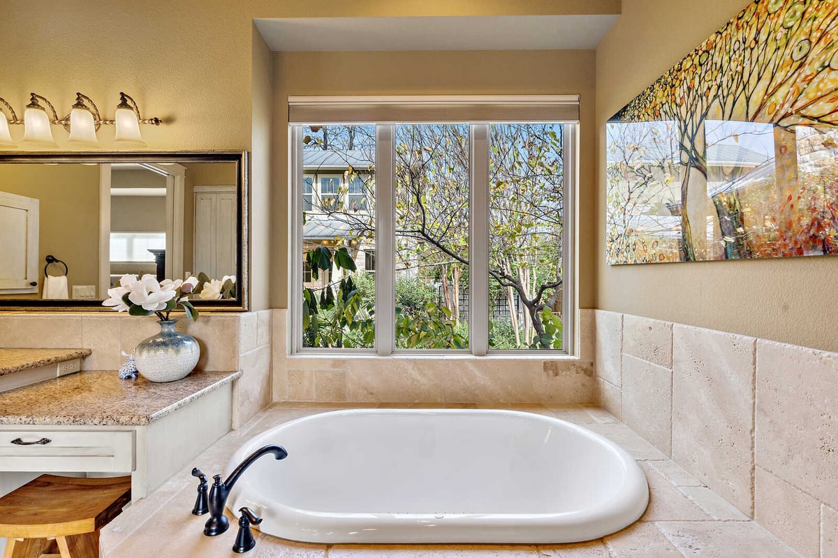 Luxurious bathroom with granite counters and detailed fixtures in a custom home by J Bryant Boyd in Georgetown, TX