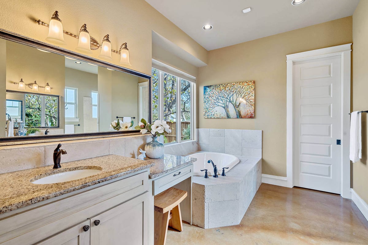 Luxurious bathroom with soaking tub and large mirror in a custom home by J Bryant Boyd in Georgetown, TX