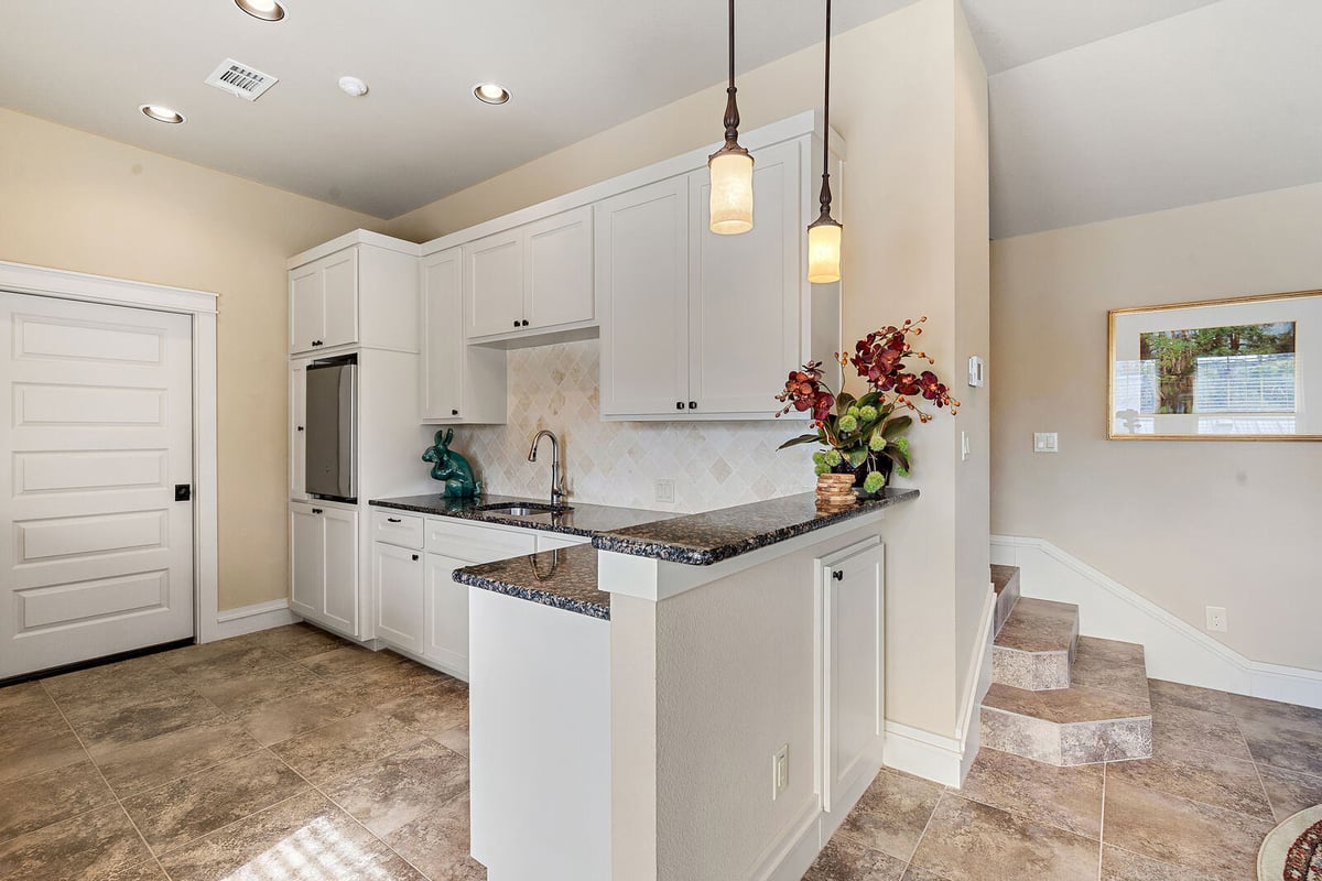 Modern kitchen with white cabinets and stainless steel appliances, custom home by J Bryant Boyd in Georgetown, TX