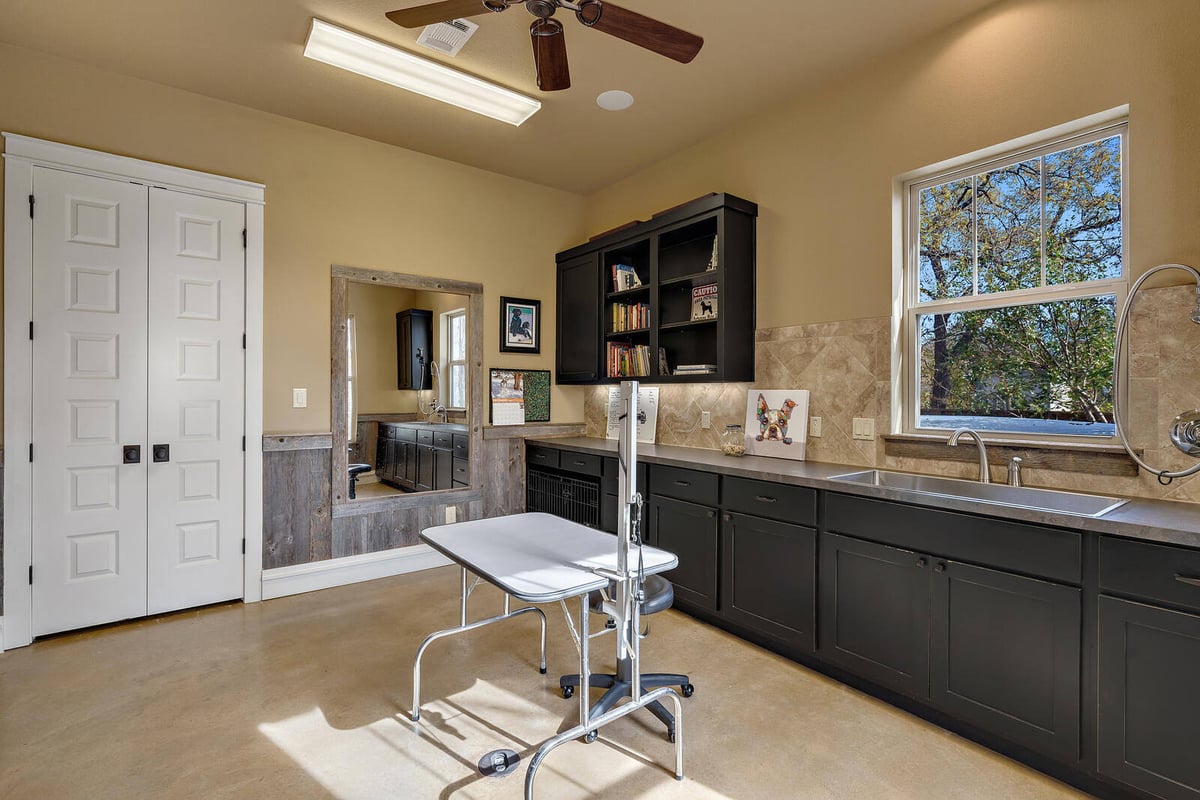 Modern laundry room with ample storage and a built-in sink in a custom Georgetown, TX home by J Bryant Boyd