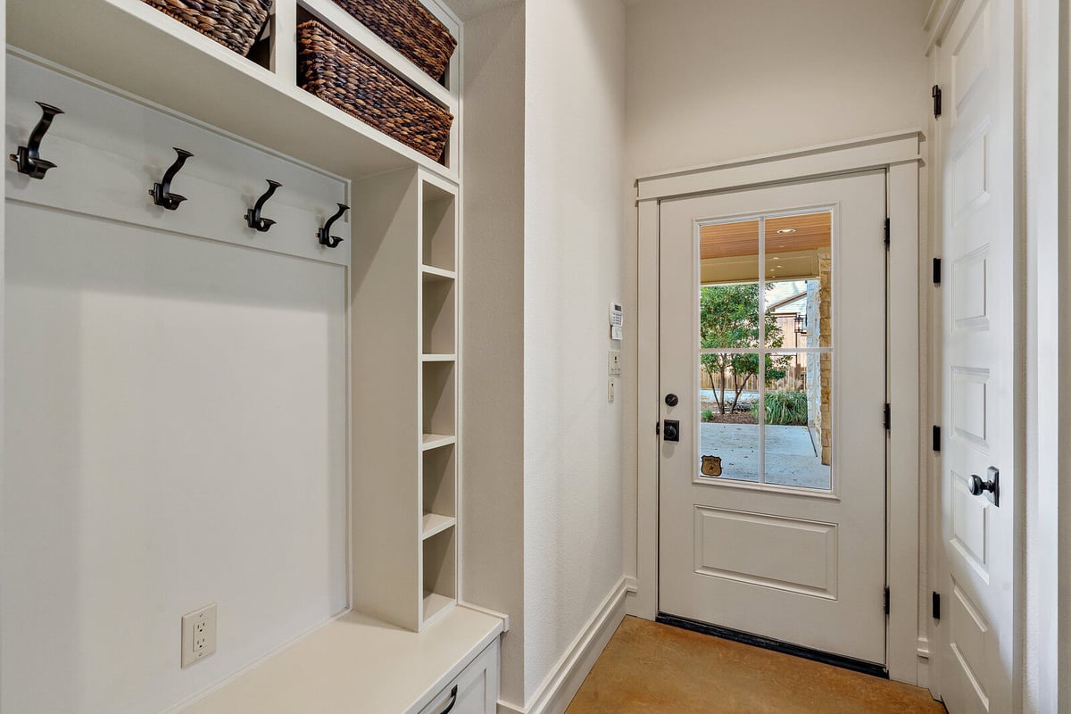 Mudroom with built-in storage and coat hooks in a custom home by J Bryant Boyd, Georgetown, TX