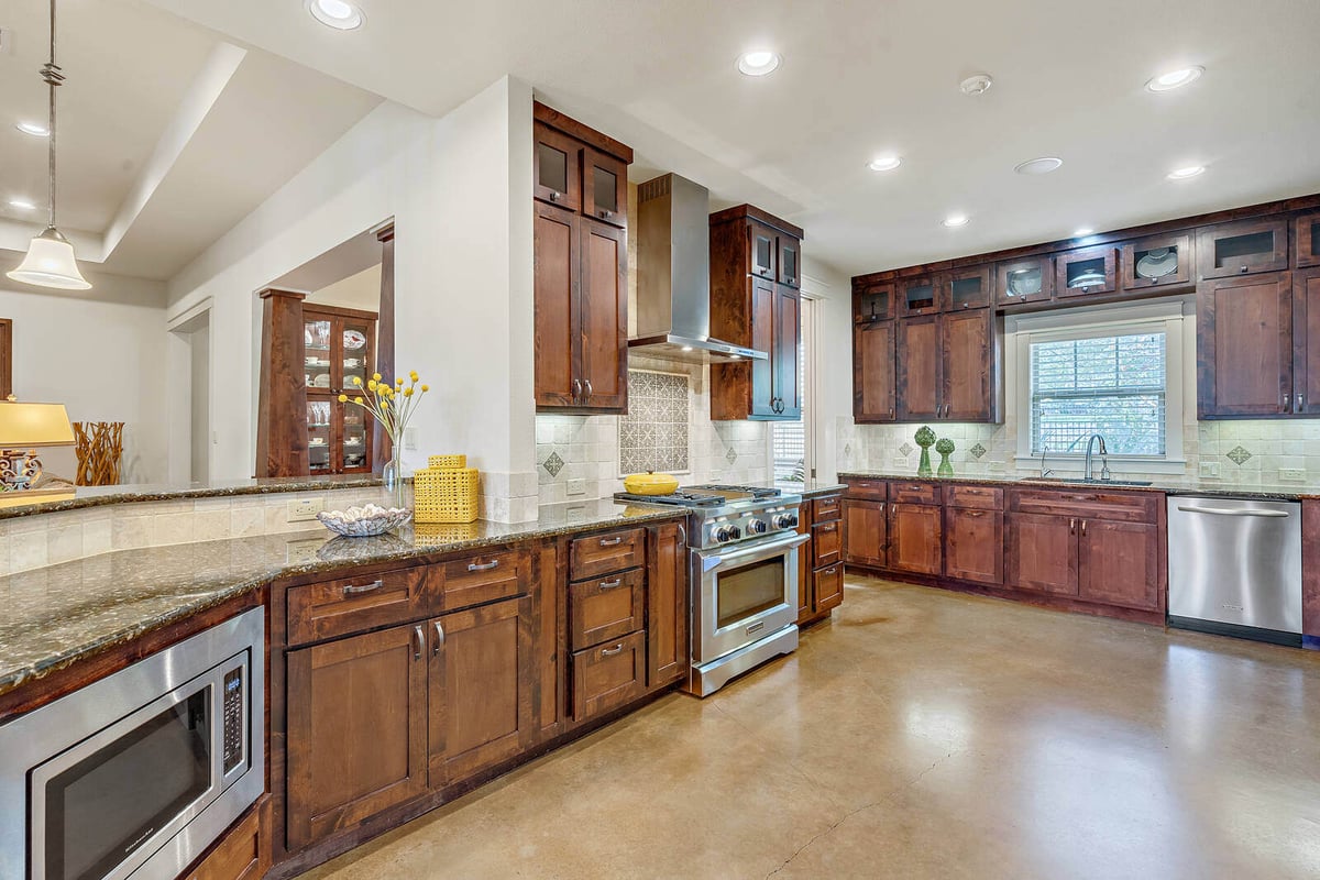 Open kitchen and living space in a custom home by J Bryant Boyd, featuring granite countertops, Georgetown, TX