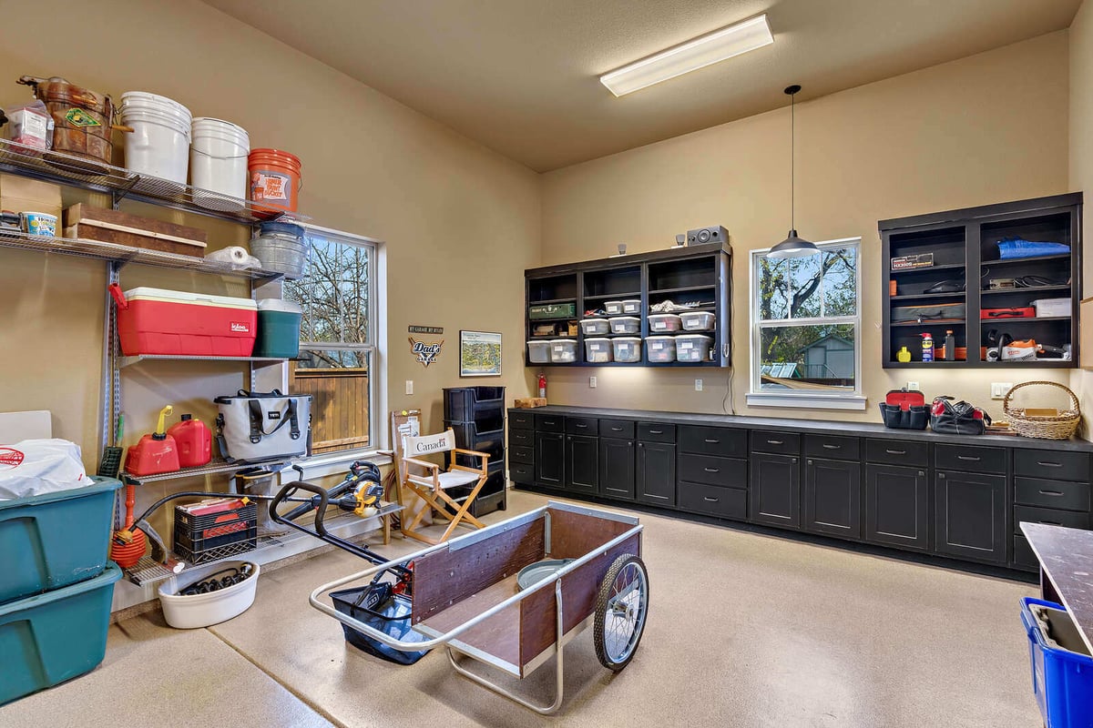 Open-plan kitchen and living area with white cabinetry and ceiling fan in a custom Georgetown, TX home by J Bryant Boyd