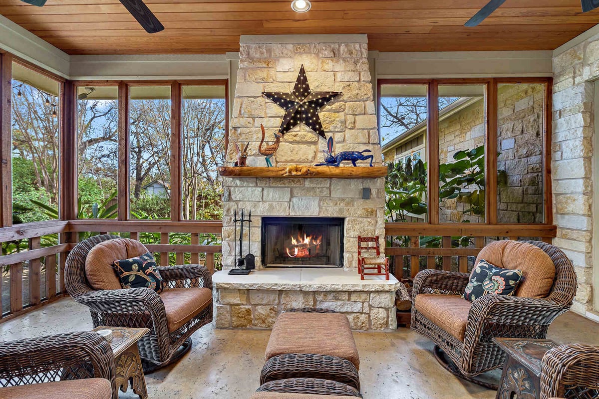 Screened-in porch with a stone fireplace and a view of the garden, custom home by J Bryant Boyd in Georgetown, TX