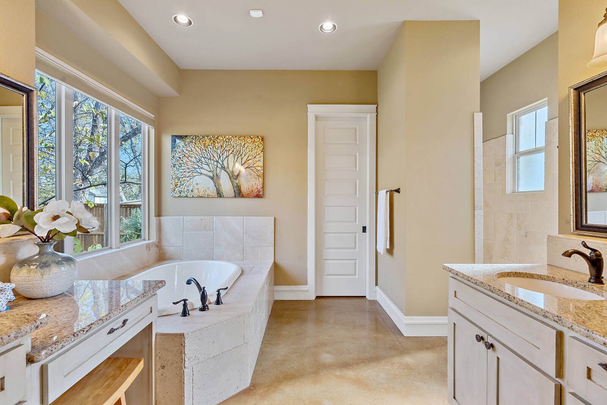 Spacious bathroom with double vanity and large windows in a custom home by J Bryant Boyd in Georgetown, TX