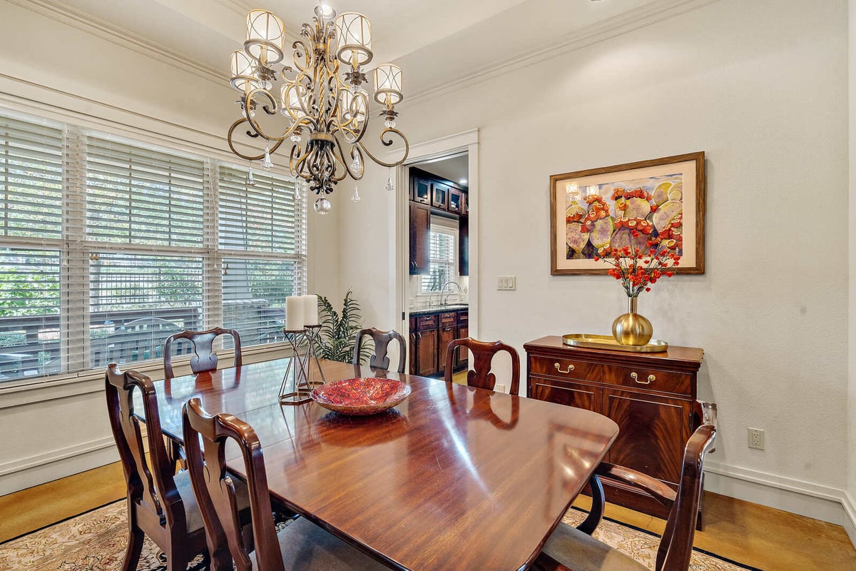 Spacious dining room with chandelier and wood furniture in a custom home by J Bryant Boyd in Georgetown, TX