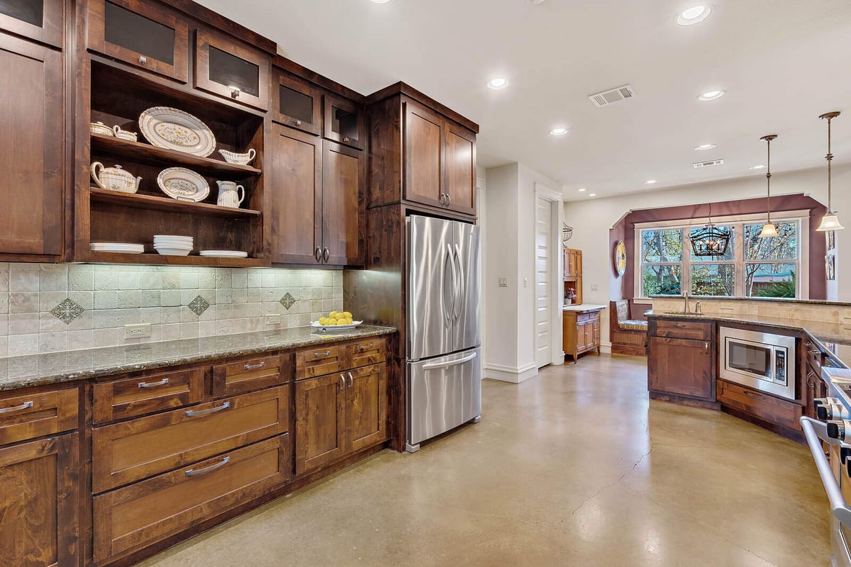 Spacious kitchen with dark wood cabinetry and open shelving in a custom home by J Bryant Boyd, Georgetown, TX