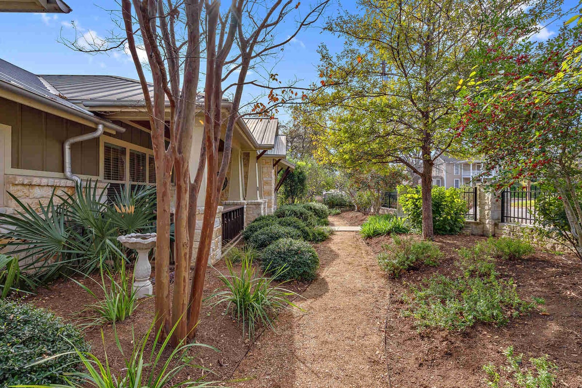 Stone-front porch with wooden door and landscaping, custom home by J Bryant Boyd in Georgetown, TX