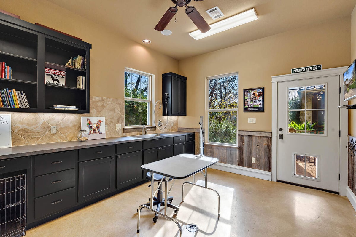 Utility room with black cabinets and organized storage in a custom Georgetown, TX home by J Bryant Boyd