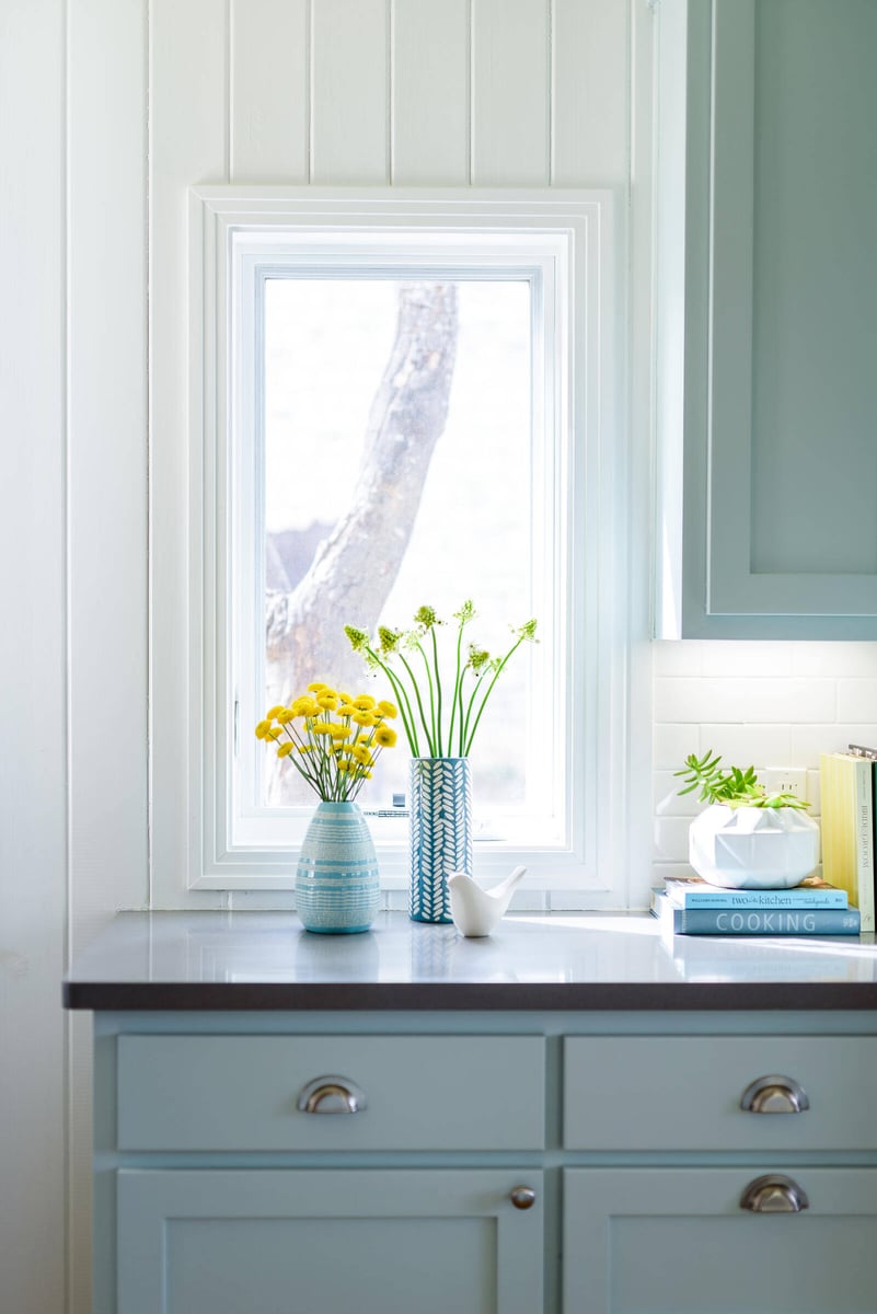 Bright kitchen window with yellow flowers on the counter in a Georgetown, TX remodel by J Bryant Boyd