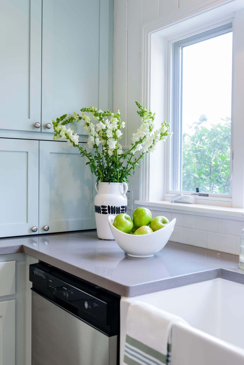 Kitchen counter with green apples and white flowers next to a window in a Georgetown, TX remodel by J Bryant Boyd