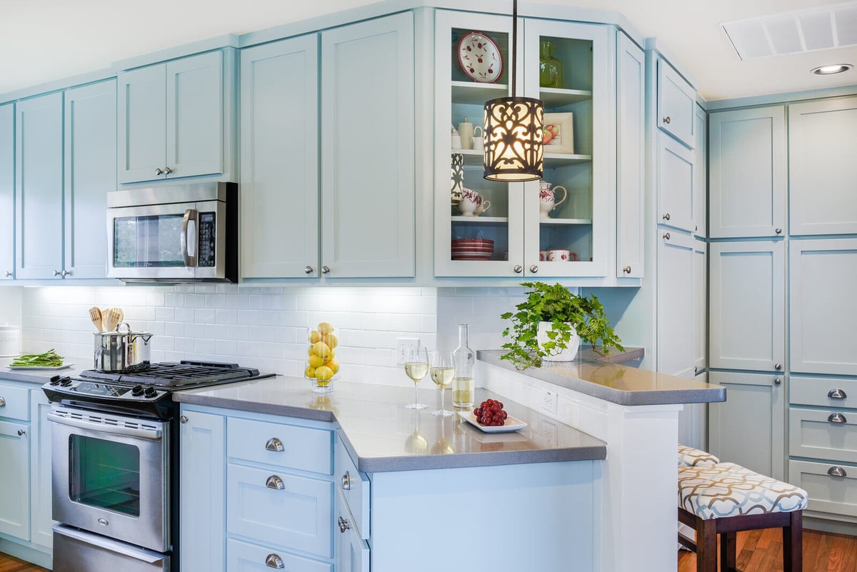 Modern kitchen remodel with light blue cabinets and stainless steel appliances by J Bryant Boyd in Georgetown, TX