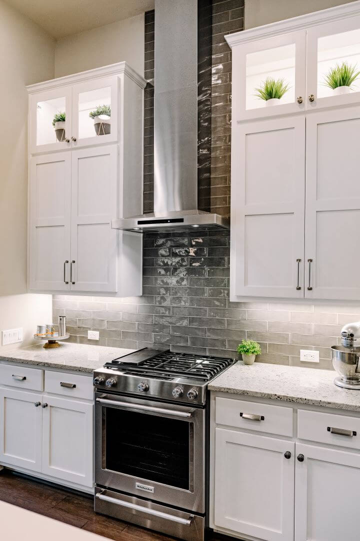 Contemporary kitchen with stainless steel range in a custom home by J Bryant Boyd in Georgetown, Texas