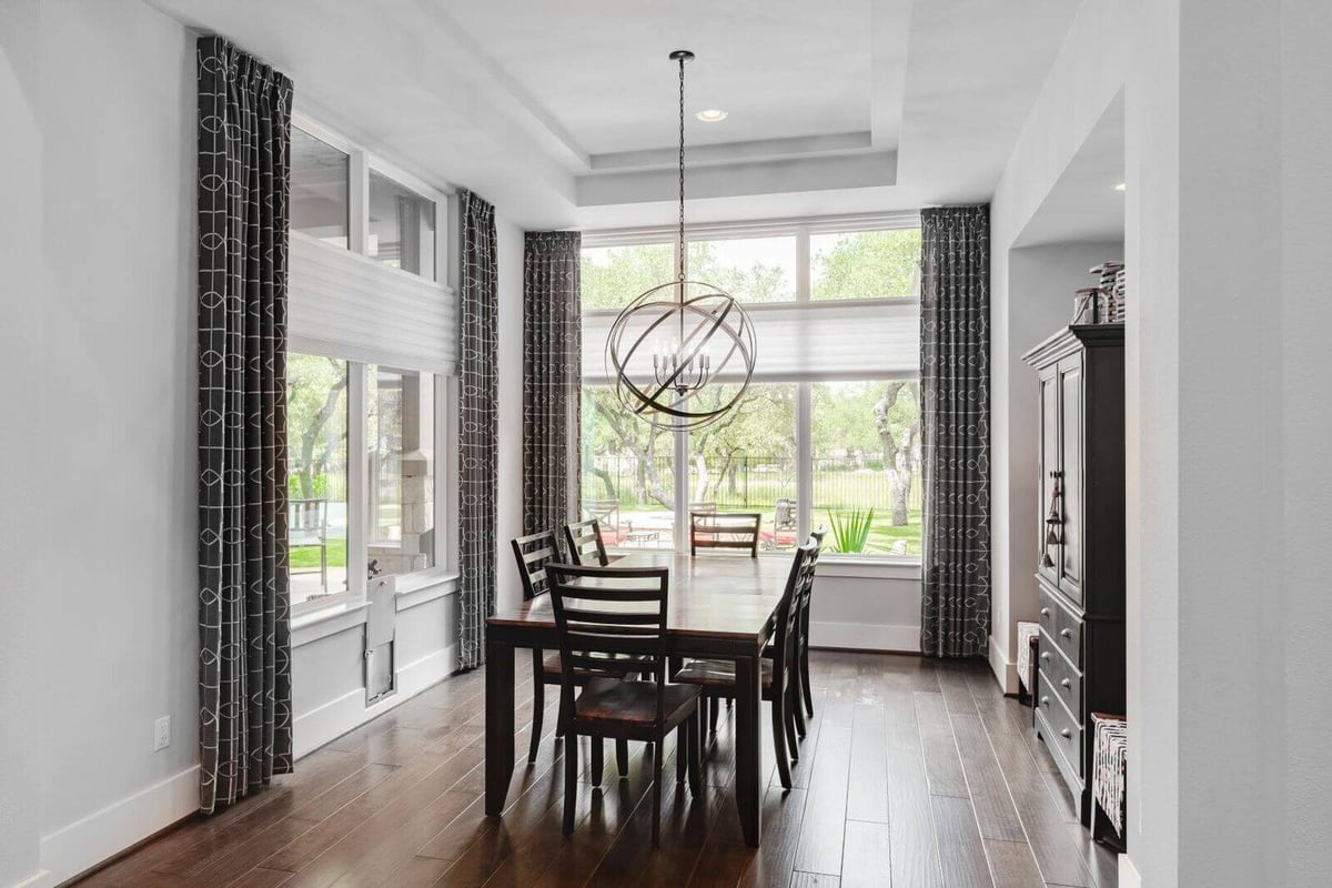 Dining room with large windows in a custom home by J Bryant Boyd in Georgetown, Texas