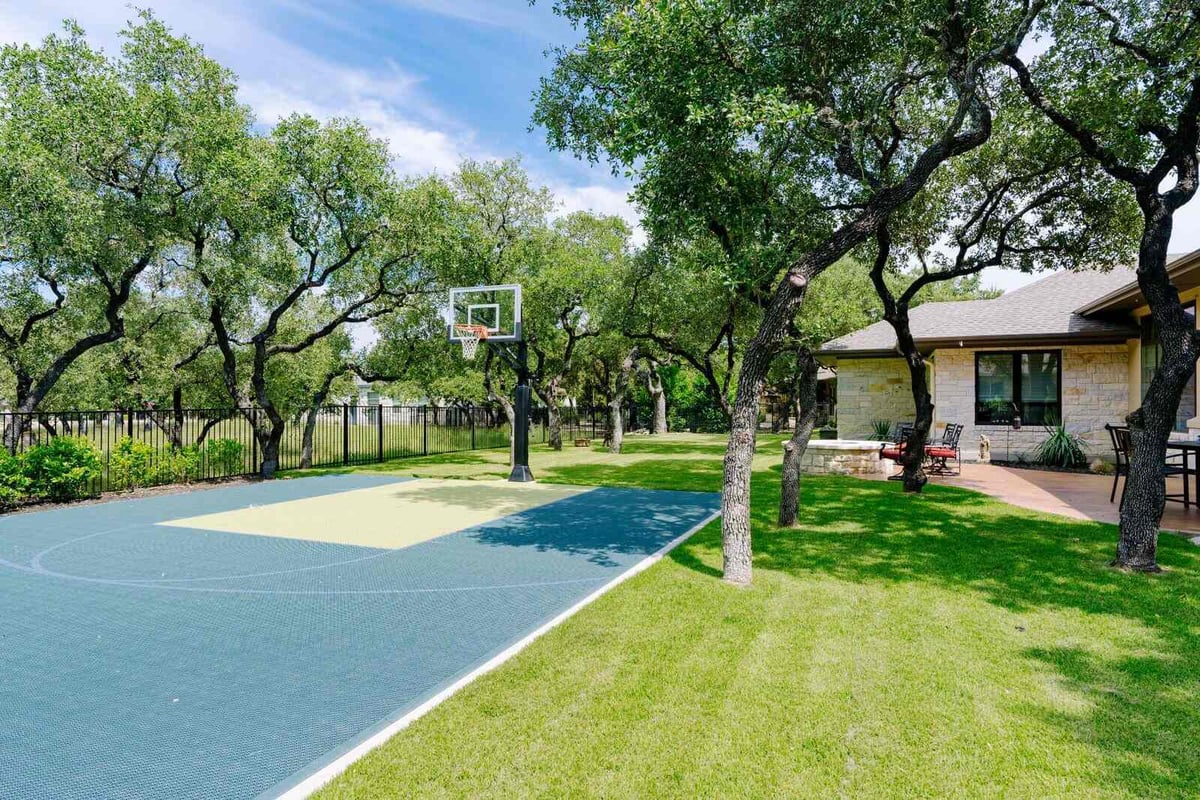 Outdoor basketball court in the backyard of a custom home by J Bryant Boyd in Georgetown, Texas