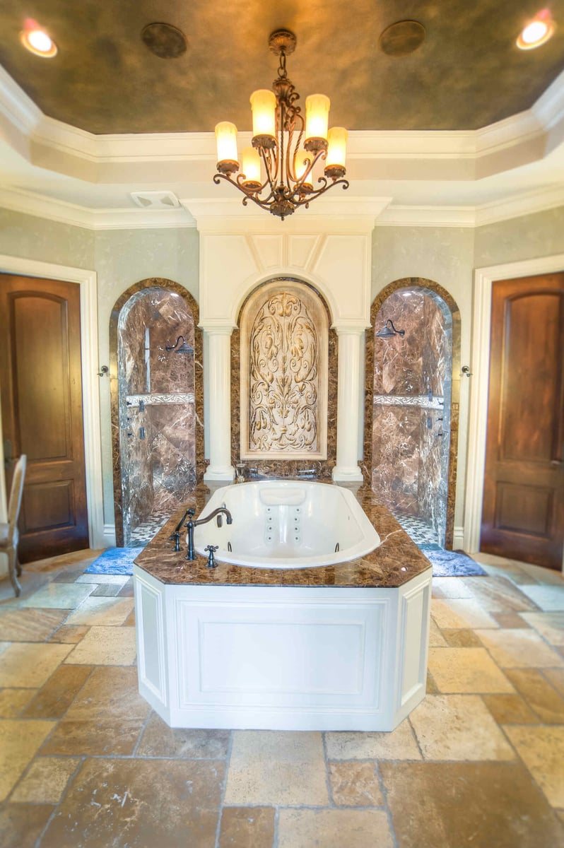 Ornate master bathroom with marble shower and centerpiece bathtub in a J Bryant Boyd custom home