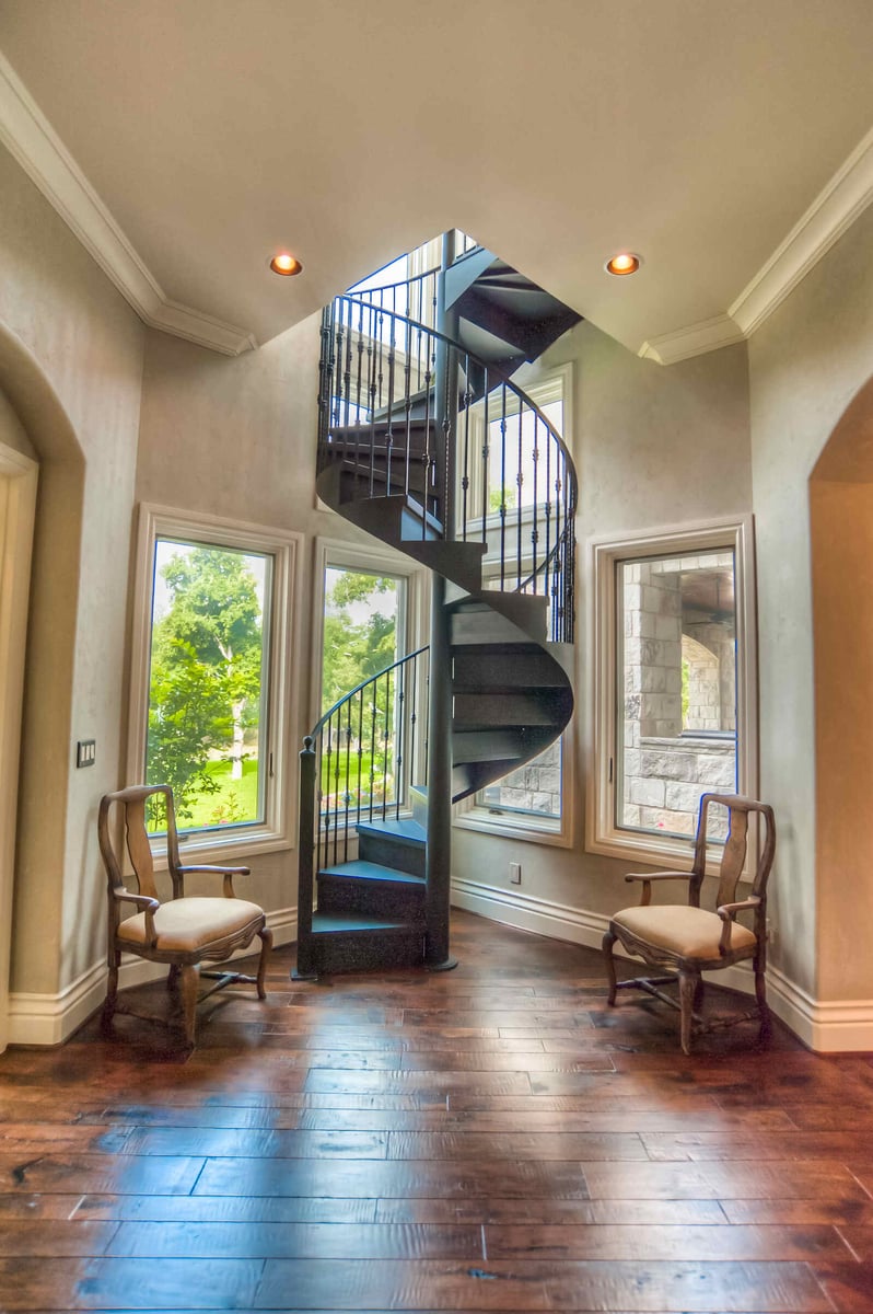 Spiral staircase with surrounding windows in a custom luxury home by J Bryant Boyd in Georgetown, TX
