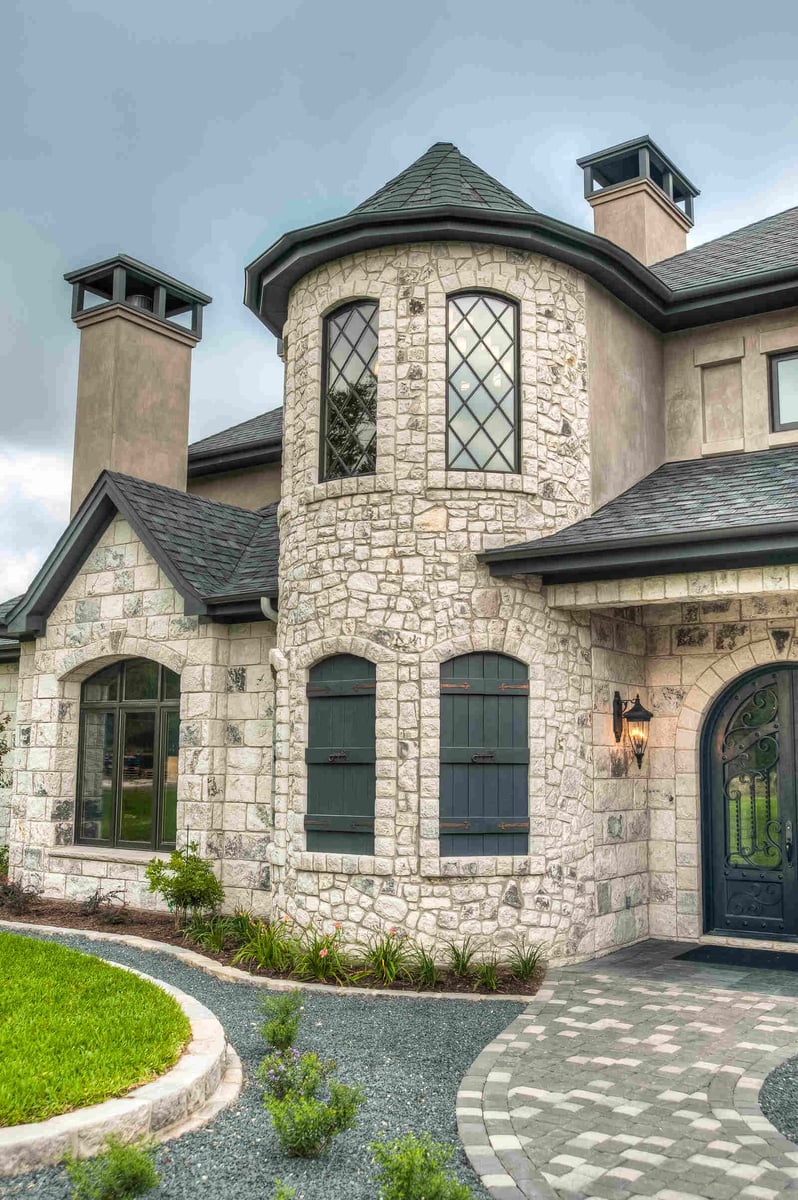 Stone turret and arched windows on a custom luxury home by J Bryant Boyd in Georgetown, TX