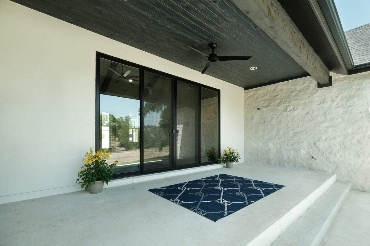 Covered patio with ceiling fan and plants by J Bryant Boyd in Georgetown, Texas