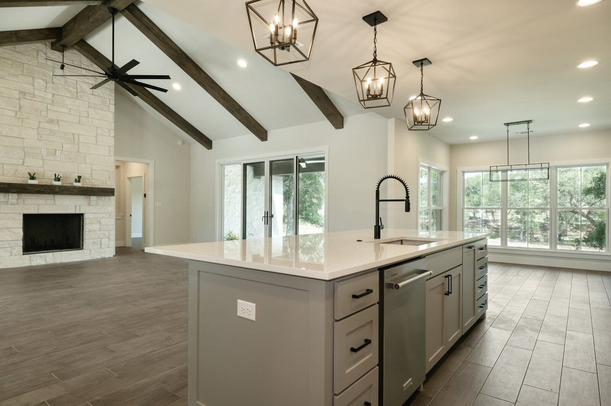 Kitchen island with modern lighting in a custom home by J Bryant Boyd in Georgetown, Texas
