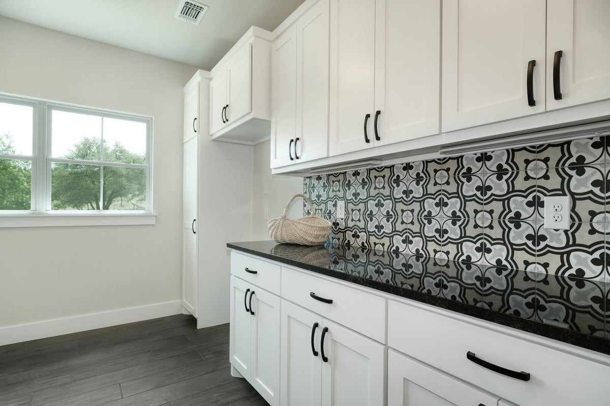 Laundry room with patterned backsplash in a custom home by J Bryant Boyd in Georgetown, Texas