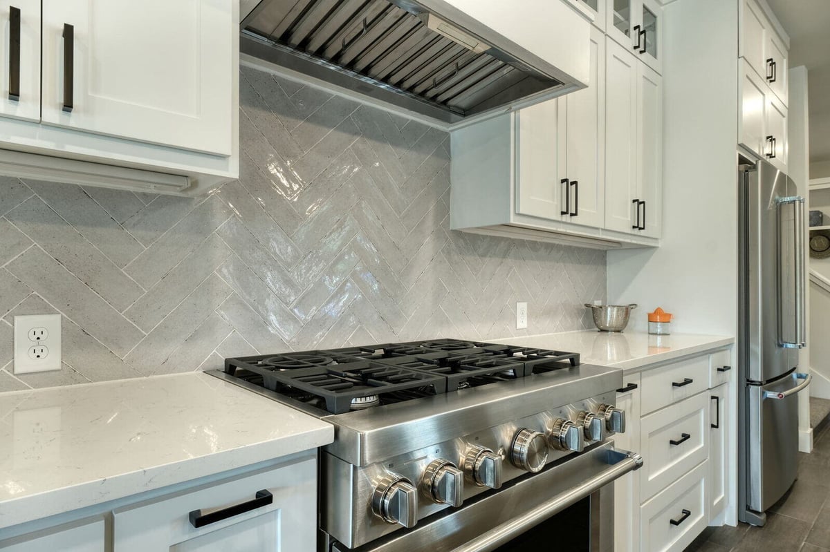 Stainless steel range and white cabinets in a custom kitchen by J Bryant Boyd in Georgetown, Texas