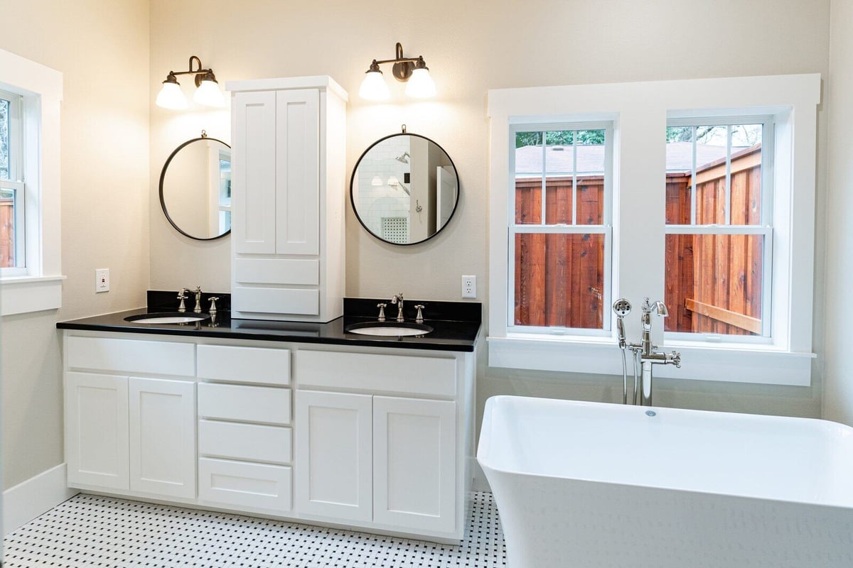 Stylish bathroom with dual sinks and round mirrors in Georgetown, Texas, by J Bryant Boyd