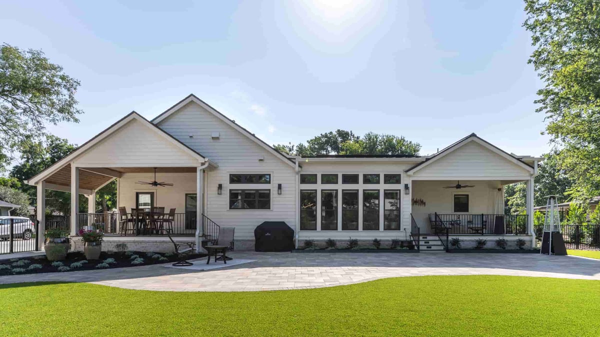 A beautiful home in Texas, showcasing a generous yard and a stylish patio, designed by J Bryant Boyd.