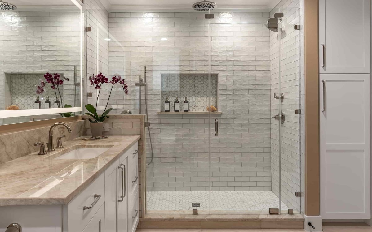 A modern Texas bathroom featuring a glass shower door and a sleek sink, designed by J Bryant Boyd.
