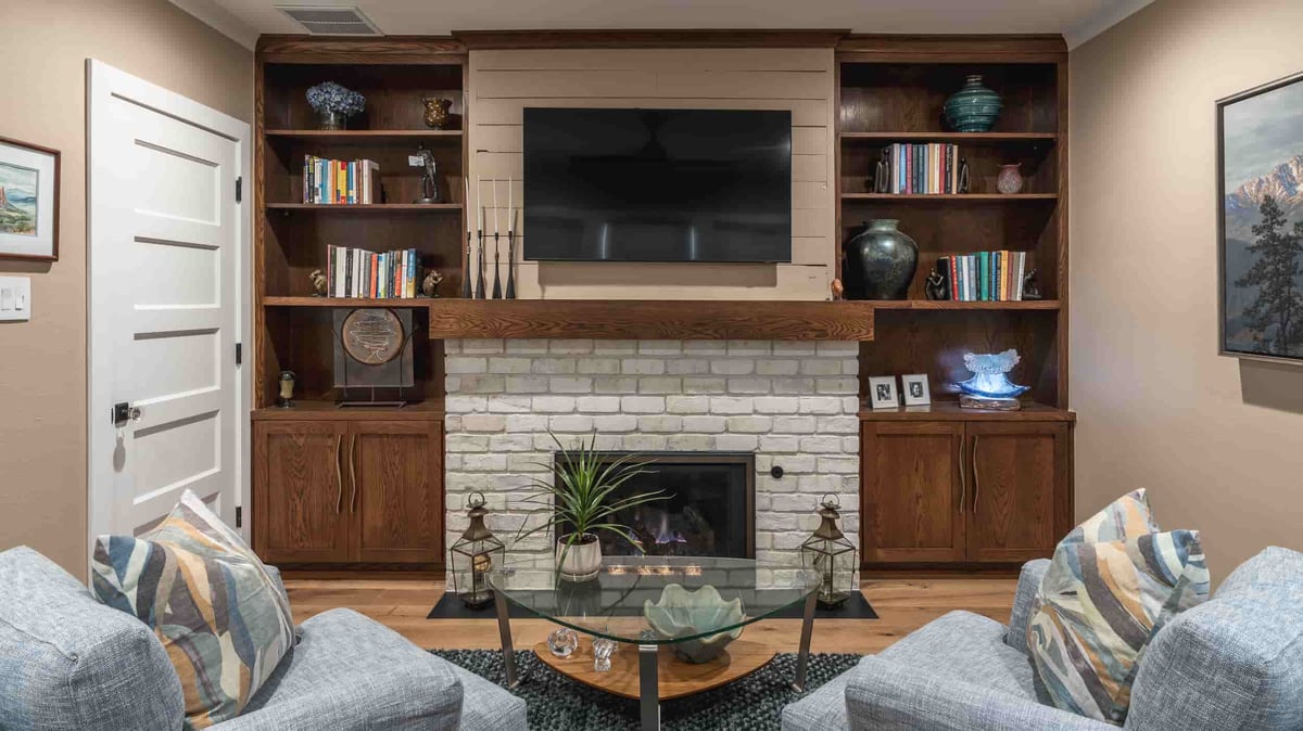  A cozy Texas living room featuring a fireplace and a television, designed by J Bryant Boyd, exuding warmth and comfort.