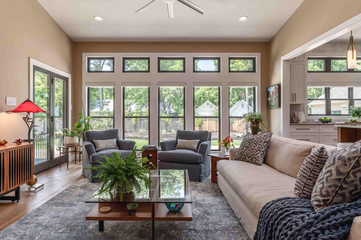 A Texas living room designed by J Bryant Boyd, highlighting a couch, coffee table, and a ceiling fan for comfort.
