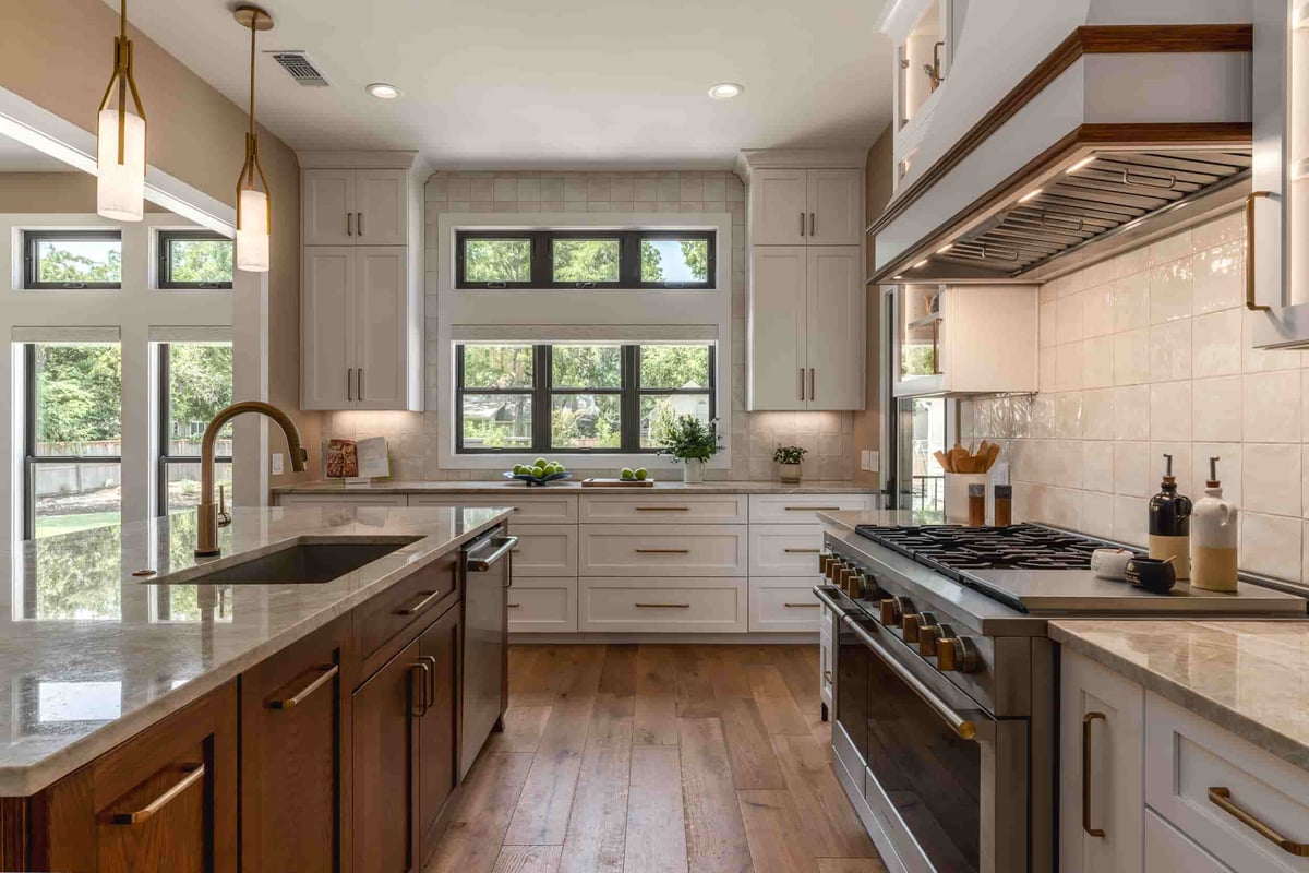  A modern kitchen in Texas by J Bryant Boyd, showcasing a central island and beautiful wooden flooring.
