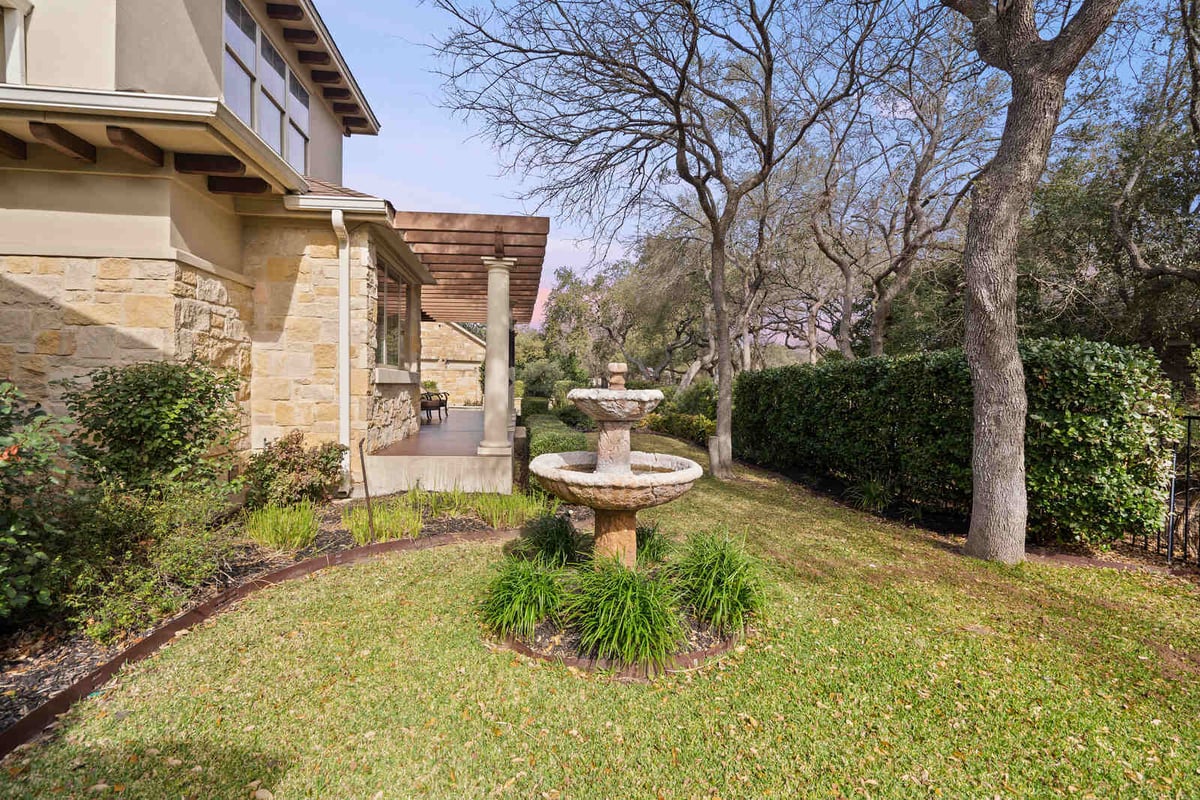Backyard garden with stone water fountain in a custom home by J Bryant Boyd, Georgetown TX-1