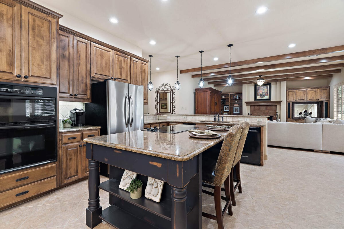 Beautifully designed kitchen in a custom home by J Bryant Boyd in Georgetown, TX, with a large island and wooden cabinetry