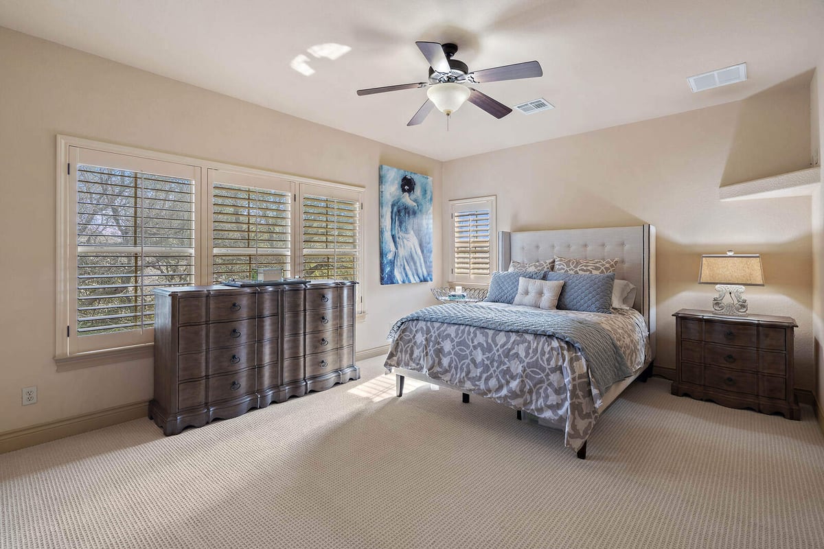 Bright master bedroom with large windows and ceiling fan in a custom home by J Bryant Boyd, Georgetown TX-1