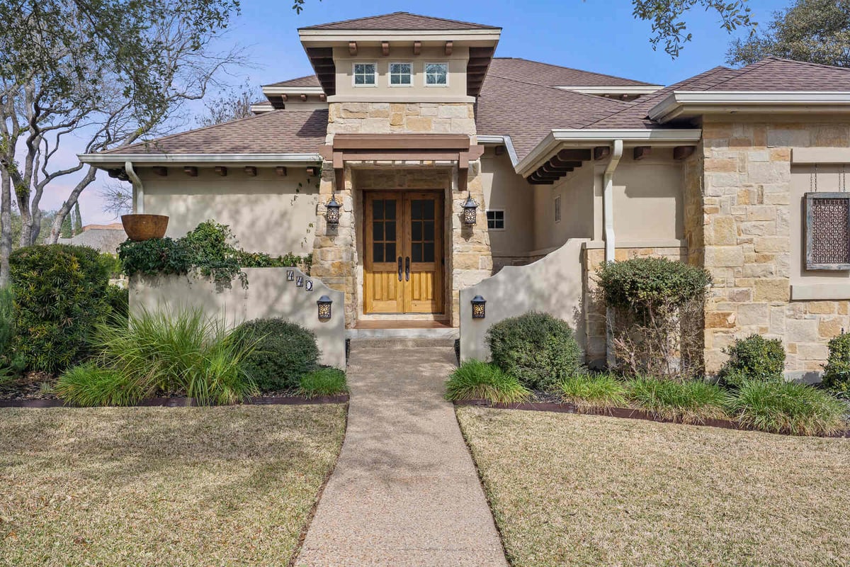 Close-up of the front entrance with wooden doors on a custom stone home in Georgetown, TX by J Bryant Boyd-1