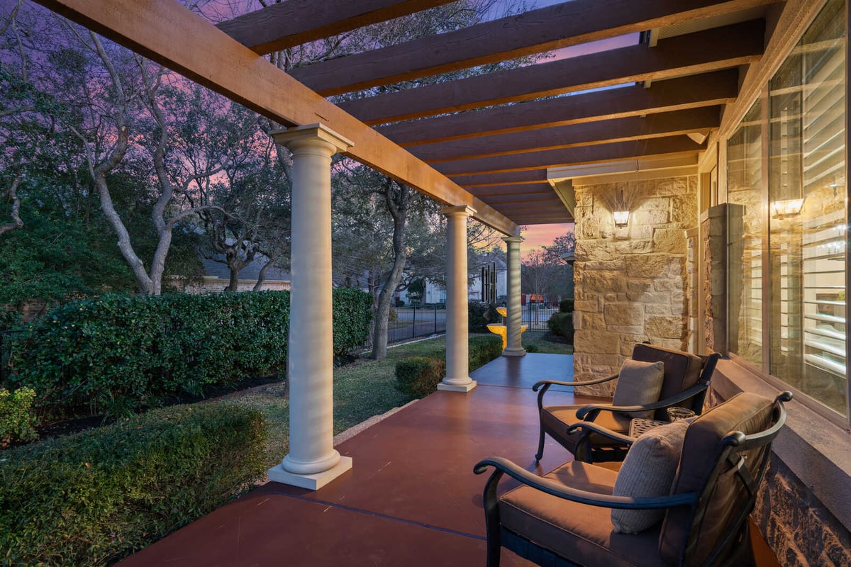 Covered patio with seating overlooking pool in a custom home by J Bryant Boyd, Georgetown, TX